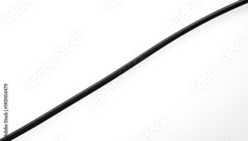 A dark cord rests on a light surface