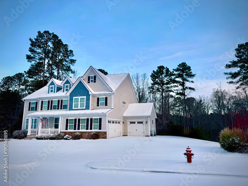 A beautiful coloniasl style family home in the snow at dawn