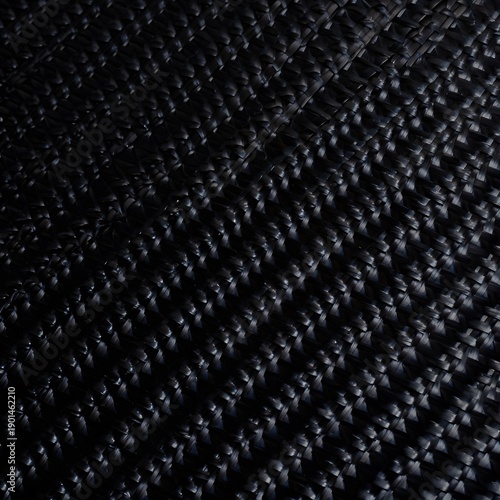 Abstract black wicker background with elegant braided texture and glossy dark material showing intricate interlocking geometric pattern for luxury modern design concepts