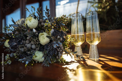 Wedding bouquet and champagne glasses with golden light