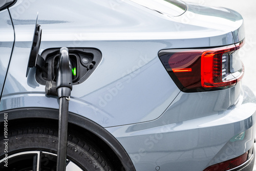 Close up of electric vehicle charging port with cable connected.