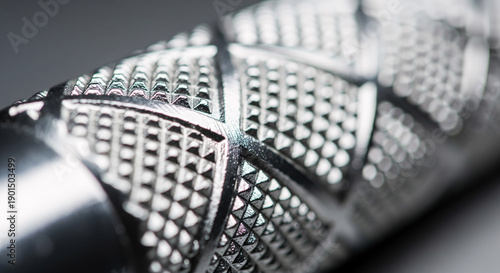 Extreme macro close up of textured silver metal knurling on gym barbell or dumbbell handle, industrial steel grip pattern with shallow depth of field, abstract shiny chrome fitness equipment detail