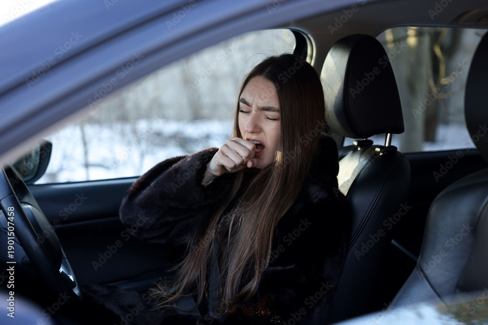 Fototapeta premium Young woman feeling fatigue in her modern car, view from outside
