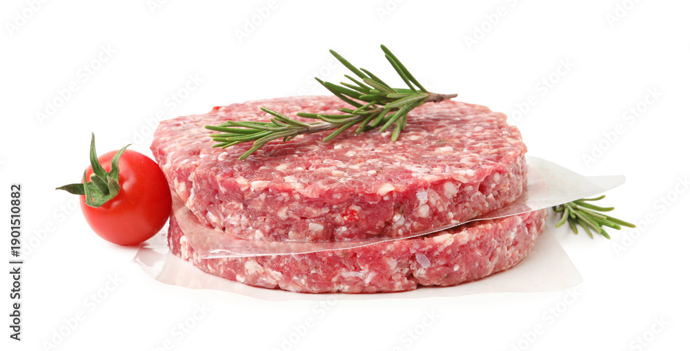 Obraz premium Uncooked meat patties with rosemary and tomato isolated on white
