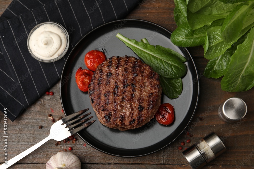 Fototapeta premium Delicious grilled meat patty, tomatoes and spinach on wooden table, flat lay