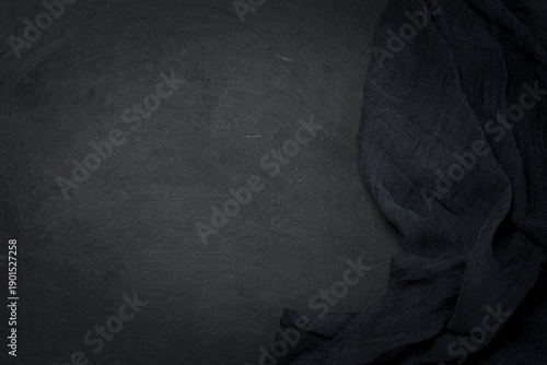 Folded black gauze kitchen napkin on black table, top view