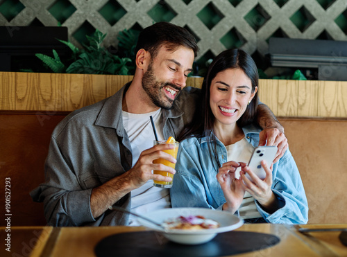 Wallpaper Mural Portrait of ayoung romantic couple in restaurant having lunch and using a mobile phone Torontodigital.ca
