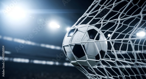 Soccer ball scoring goal in stadium net under bright stadium lights with dramatic lighting and blurred background