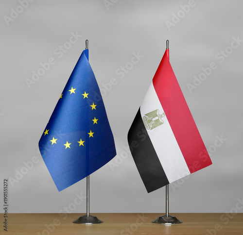 Two table flags of the European Union and Egypt on a blurred gray background