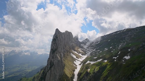 Majestic Saxerlucke Over Clouds. Snowy Ridges with Lush Green Fields
