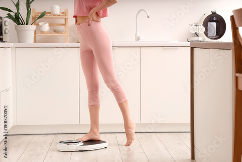 Woman measuring her weight ...