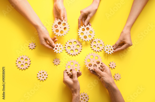 Hands holding wooden gears ...