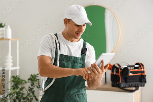 Male plumber using tablet c...