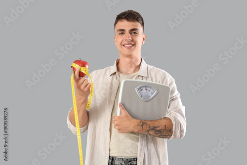 Young man with weight scale...