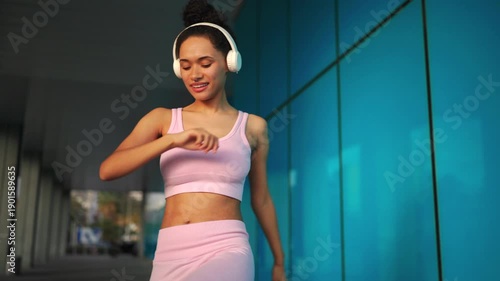 Wallpaper Mural Woman doing outdoor fitness workout, stretching legs with headphones on, calm expression, urban wellness routine, recovery phase, balance, healthy lifestyle focus Torontodigital.ca