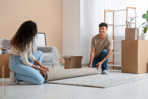 Young couple placing carpet...
