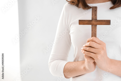 Young woman praying with cr...