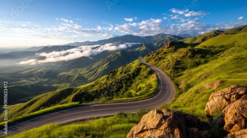 Scenic Mountain Road with Switchbacks Revealed Through Lifting Morning Fog at Dawn