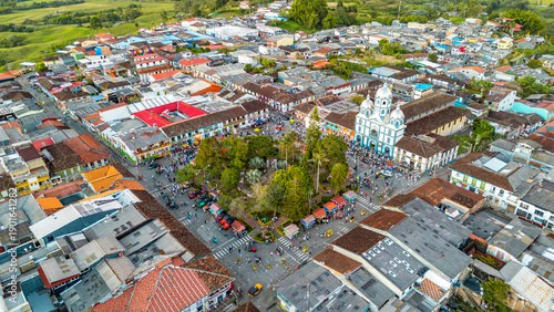 An aerial shot showcasing the vibrant rooftops of Filandia, with a crowded plaza and lush greenery.
