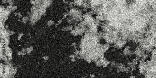 Abstract close-up of dark, irregular shapes with a speckled texture against a lighter gray background, creating a textured abstract surface for design