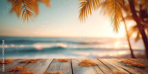 A serene beach scene at sunset, featuring golden leaves on a wooden deck with palm trees and gentle ocean waves in the background.