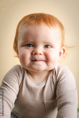 Obraz na plátne red headed one year old baby in front of a neutral background in studio