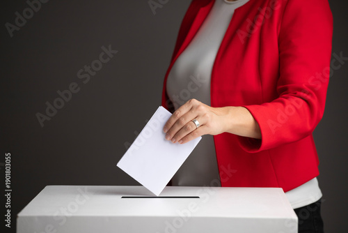 The voter holds his vote ballot paper and places it in the ballot box. Election concept.