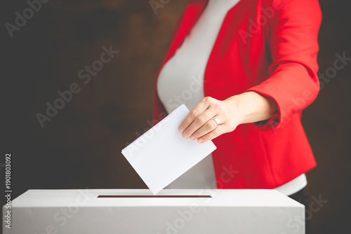 The voter holds his vote ballot paper and places it in the ballot box. Election concept.