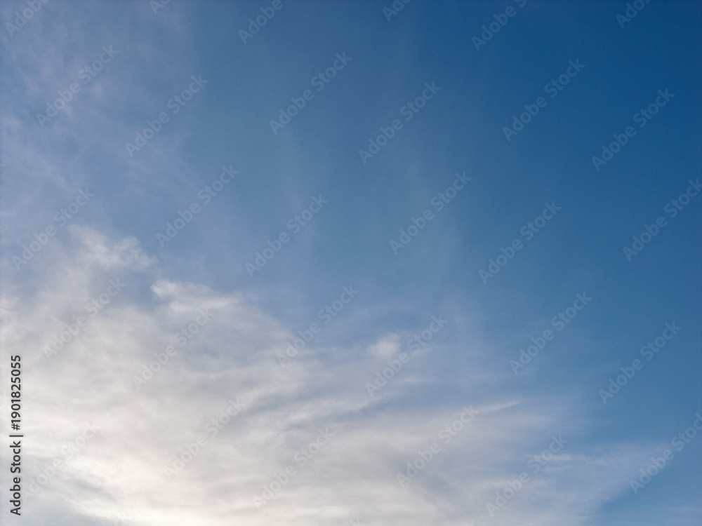 Fototapeta premium Blue sky and light feathery white clouds creating a peaceful and expansive backdrop, ideal for natural themes, weather concepts, or copy space designs