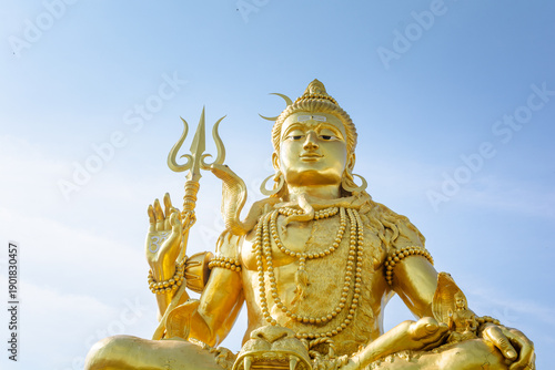 Golden Shiva statue with blue sky, Big statue hindu god and spiritual landmark in Thailand
