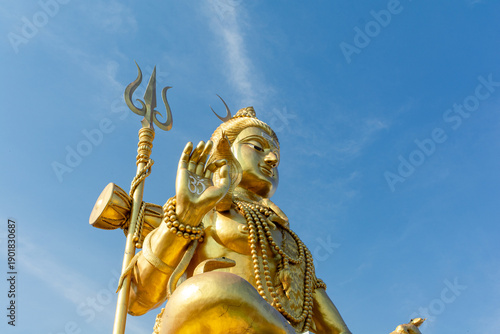 Golden Shiva statue with blue sky, Big statue hindu god and spiritual landmark in Thailand