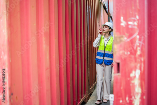 Foto Female professional walking through industrial container area showing business w