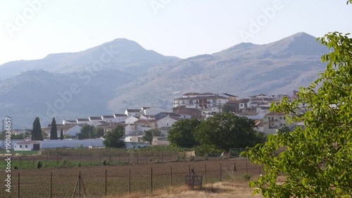 Traditional white houses of Zafarraya, nestled at the foot of towering mountains. Typical Andalusian architecture surrounded by farmland and unspoiled nature.