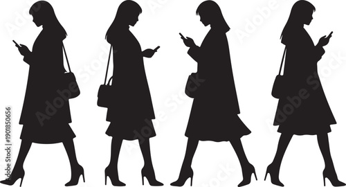 Four women walking and using their smartphones in a line.