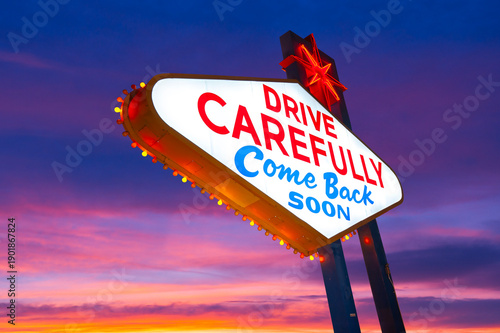 Drive Carefully Come Back Soon Sign, Welcome to Fabulous Las Vegas Sign. Logo Removed. The beautiful sunset sky in the background.