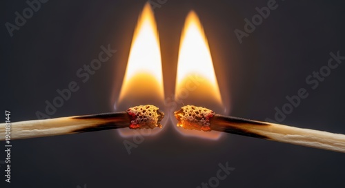 Close-up of two burning matches with fiery orange flames on dark background highlighting combustion and energy