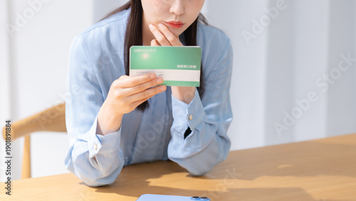 Tableau sur toile 通帳を見て悩む女性