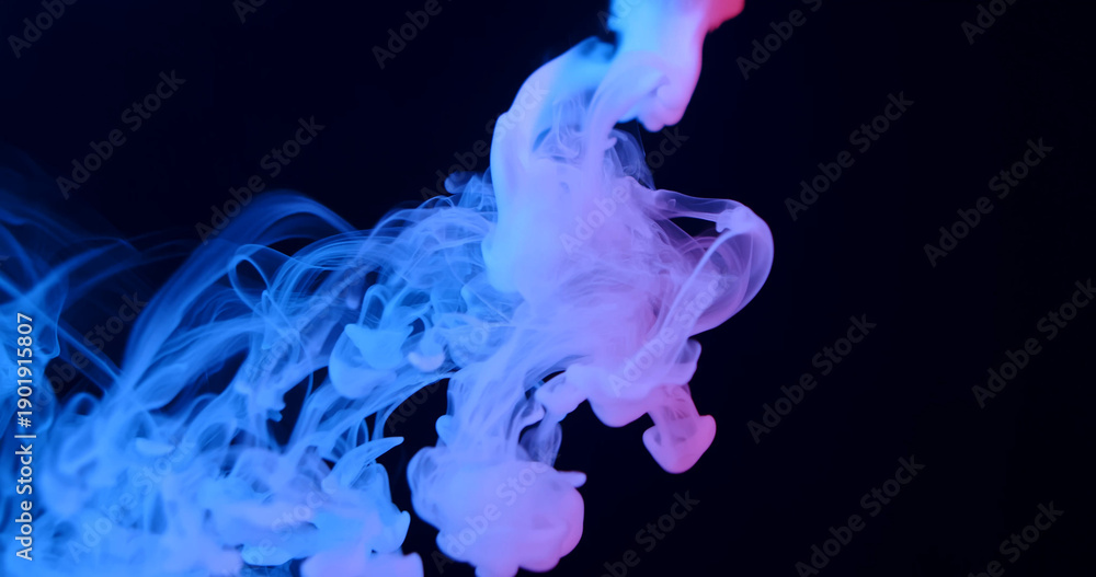 Fototapeta premium Ethereal blue smoke swirls elegantly against a dark background, creating a mysterious and atmospheric scene.