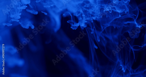 An abstract photo featuring blue smoke swirls against a dark background, creating a mystical atmosphere.