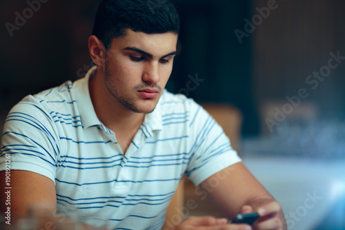 Quadro su tela Sad Man Holding His Phone Reading a Text Message