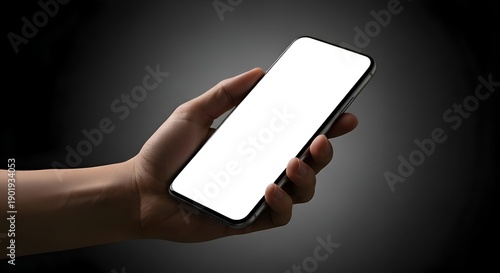 Human Hand Holding Blank Smartphone Display Against Dark Backdrop with Focused Lighting and High Contrast