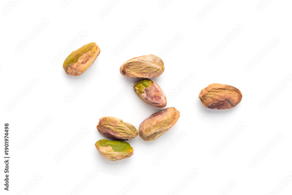 Obraz premium Fried salt pistachio nuts isolated. Baked pistachios pile, roasted green pistache fruits on white
