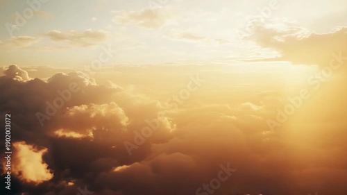Fluffy cumulus clouds bathed in warm golden sun rays, creating a serene, atmospheric aerial view above the horizon at sunrise or sunset, evoking peace and hope