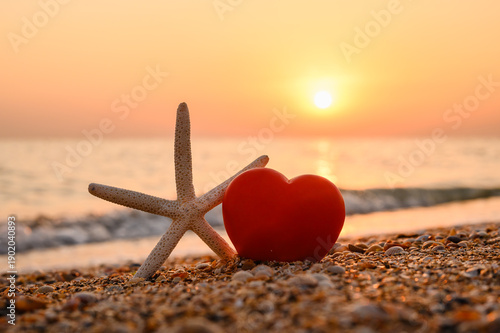A warm seaside sunset. A romantic postcard with a heart by the sea.