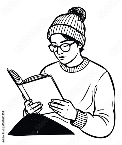 A focused individual wearing a cozy winter beanie and stylish eyeglasses is deeply engrossed in reading a book, perfect for educational materials or cozy lifestyle content.