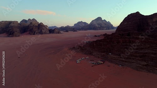Wallpaper Mural A peaceful drone footage gliding over a remote desert resort in Wadi Rum, featuring glowing tents and silhouettes of sandstone mountains at twilight Torontodigital.ca