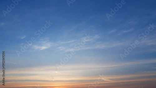 A sunset sky timelapse video with layered cirrus and altostratus clouds glowing in pink, orange, and purple tones, capturing smooth cloud movement and serene evening atmospheric transitions.
