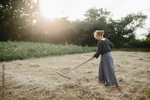 Photography Woman raking hay in a ukrainian village field