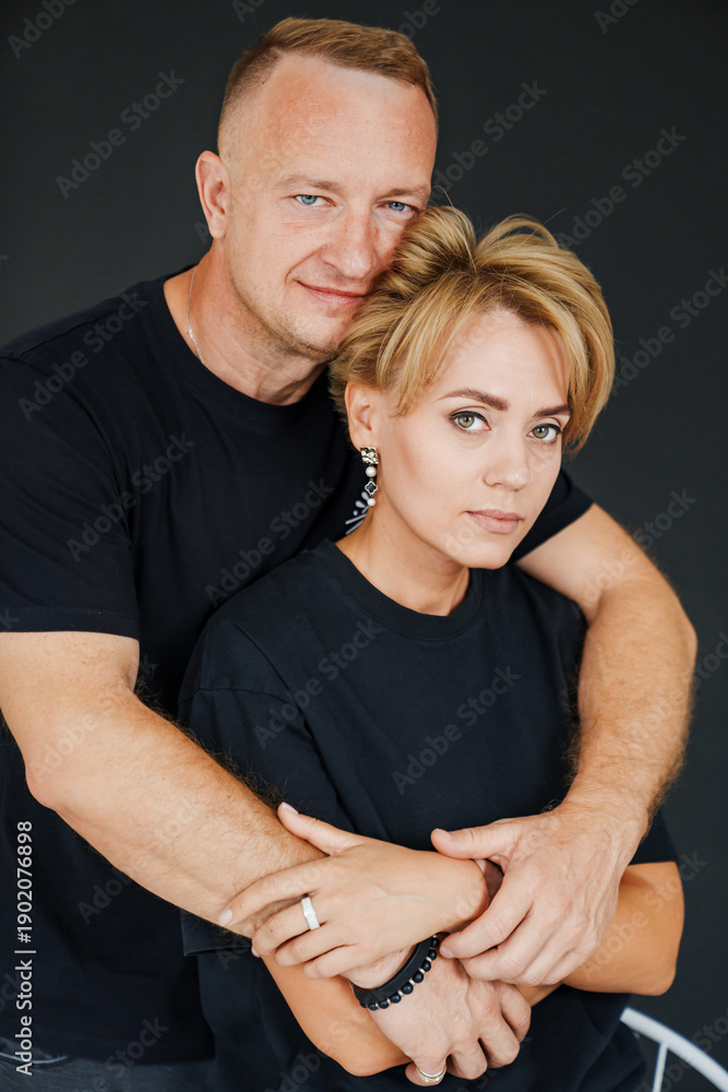 Fototapeta premium Couple embraces in a studio setting during a casual moment together