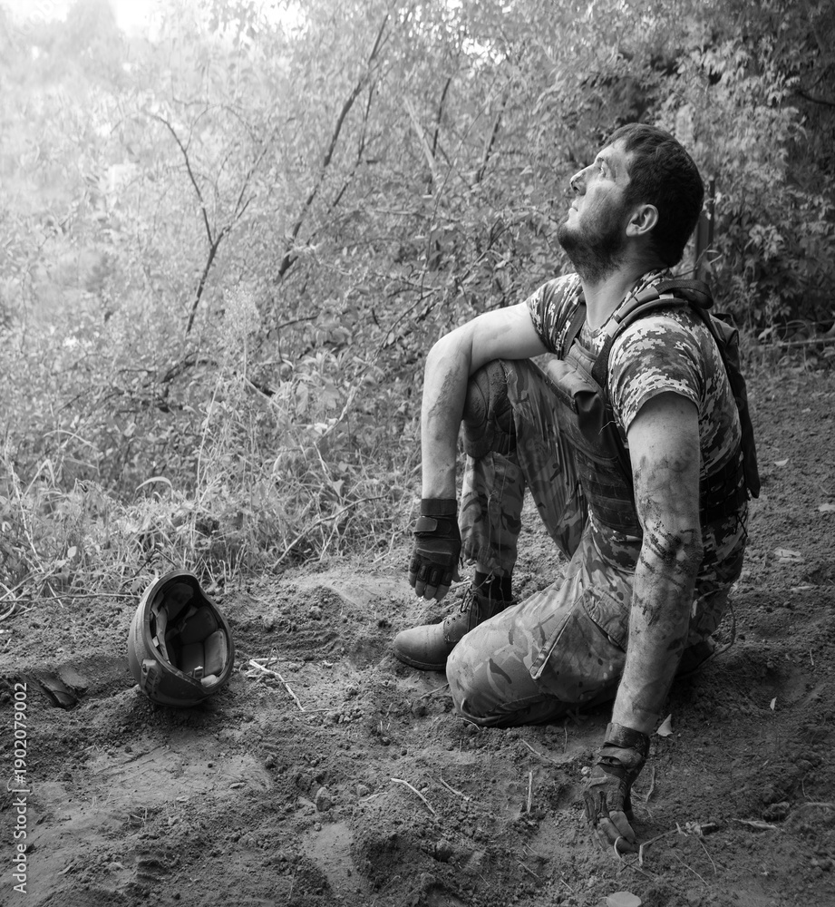 Naklejka premium Young soldier sitting on the ground